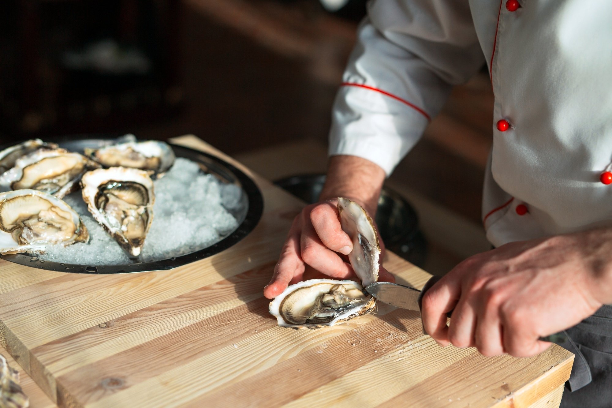 Chef abriendo ostra, ostiones