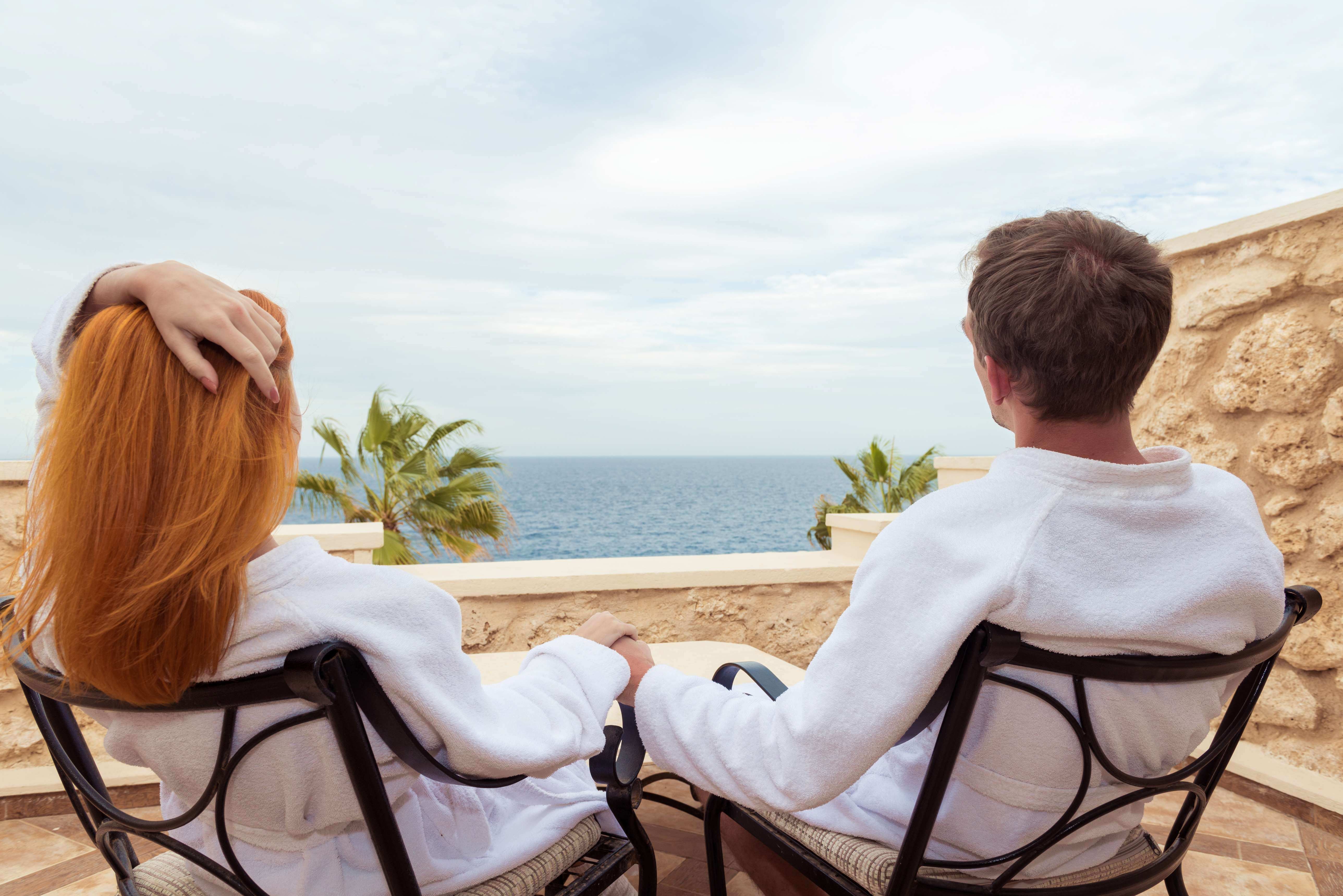 Pareja disfrutando la vista al mar desde la terraza